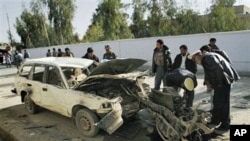 Afghan traffic officers check the engine which is all that remained of the vehicle used in a car bomb explosion, beside a damaged vehicle, after an explosion in Kandahar, south of Kabul, 11 Dec 2010