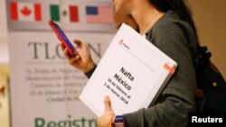 A member of the Mexican negotiation team checks her phone during a lunch break at the hotel where the seventh round of NAFTA talks involving the United States, Mexico and Canada takes place, in Mexico City, Mexico, Feb. 28, 2018.