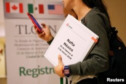 A member of the Mexican negotiation team checks her phone during a lunch break at the hotel where the seventh round of NAFTA talks involving the United States, Mexico and Canada takes place, in Mexico City, Mexico, Feb. 28, 2018.