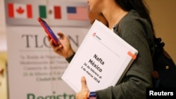 A member of the Mexican NAFTA negotiation team checks her phone during a lunch break in Mexico City, Mexico, Feb. 28, 2018.