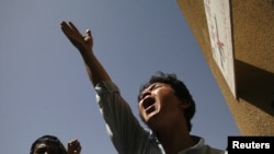 An ethnic Hazara Shi'ite Pakistani Muslim shout slogans while condemning the killings of relatives outside a hospital, where their bodies are located, in Quetta, September 1, 2012. 