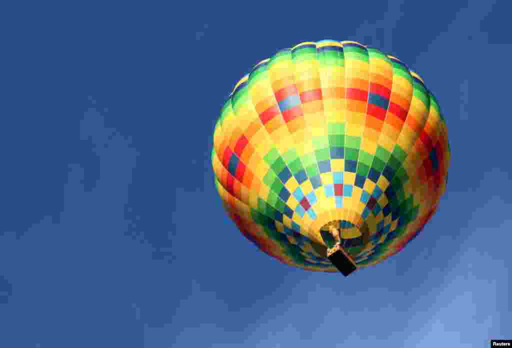 A hot air balloon floats over Balloon Fiesta Park in advance of the annual Albuquerque International Balloon Fiesta in Albuquerque, New Mexico. The nine-day event begins Saturday with a mass ascension and attracts hundreds of balloonists and thousands of spectators from around the world.