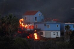 Lava from the Cumbre Vieja volcano burns a house on the Canary Island of La Palma, as seen from Tajuya, Spain, October 19, 2021. (REUTERS/Susana Vera)