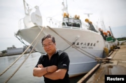 Shigeru Saito, captain of the squid fishing ship Hosei-Maru No.58, poses for a photograph in front of his ship at a port in Sakata, Japan, June 5, 2018.
