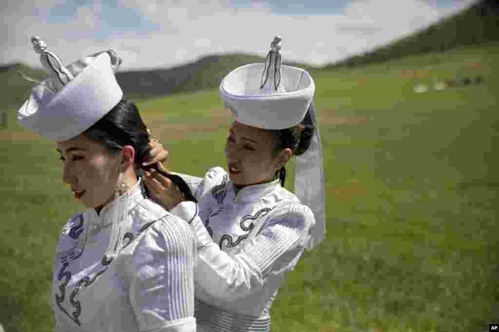 A performer helps another with her hair before a shortened version of a Naadam festival, a traditional Mongolian cultural and sporting event, held during the 11th Asia-Europe Meeting (ASEM) in Ulaanbaatar, Mongolia.