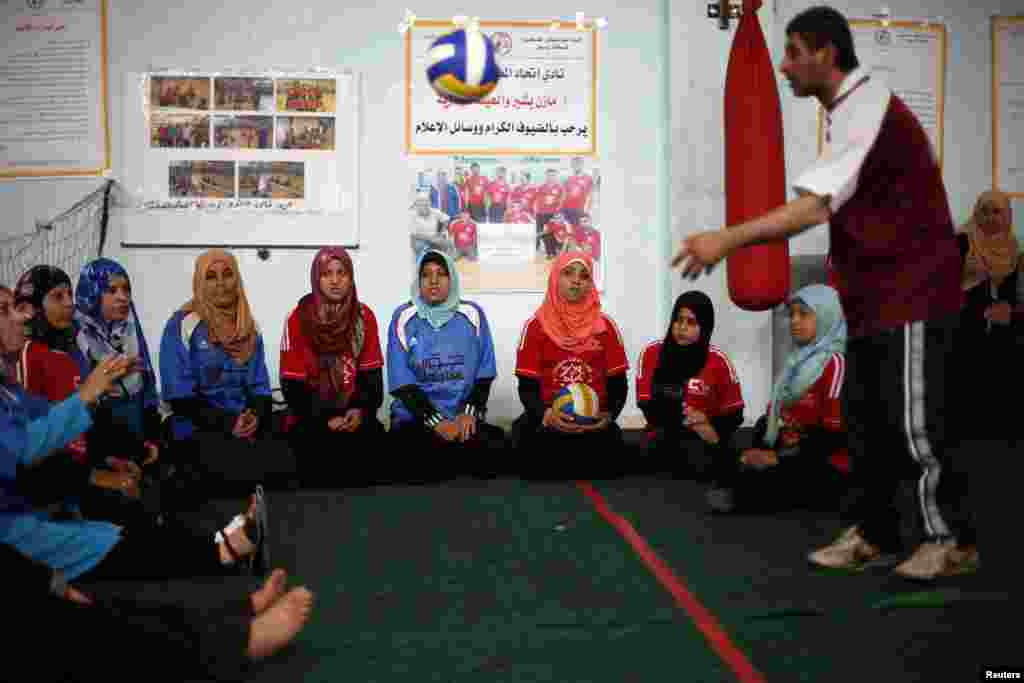 ایک ٹرینر معذور فلسطینی لڑکیوں کو والی بال کی تربیت دے رہا ہے۔