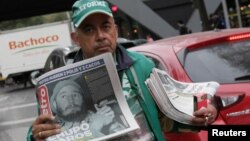 Seorang pedagang kaki lima menjual salinan surat kabar Metro, harian terkemuka Meksiko yang menampilkan gambar Fidel setelah pengumuman kematian pemimpin revolusioner Kuba Fidel Castro, di Mexico City, Meksiko (26/11). 