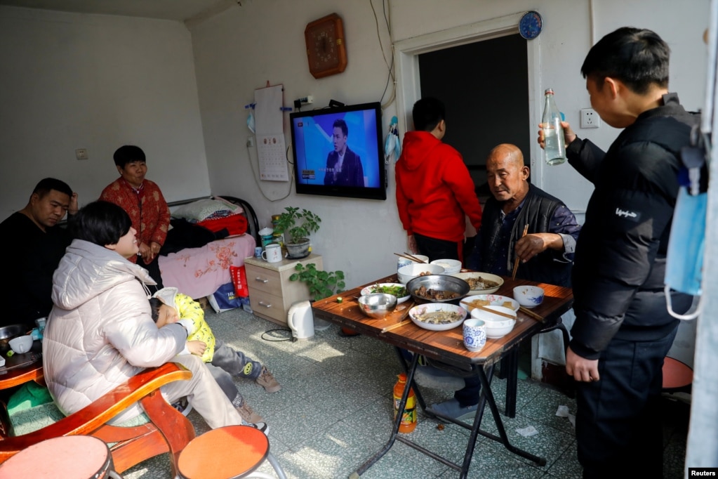 在北京打工的杨念连（音）和他租住的京郊马驹桥小区的房东一家人一起过年。（2021年2月11日）(photo:VOA)