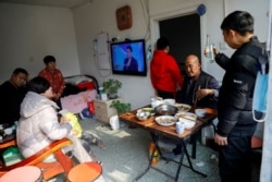 在北京打工的杨念连（音）和他租住的京郊马驹桥小区的房东一家人一起过年。（2021年2月11日）