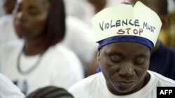 "A violência tem que parar", lê-se no chapéu desta mulher, participante numa campanha das Nações Unidas contra a violência dirigida às mulheres e raparigas (foto de arquivo)