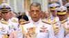 FILE - Thai King Maha Vajiralongkorn, center, holds a candle light during a ceremony at Emerald Buddha temple, in Bangkok, Thailand, May 29, 2018.