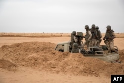 FILE - Soldiers of the Mauritania Army wait in an armed vehicle at a G5 Sahel task force outpost in the southeast of Mauritania, along the border with Mali, Nov. 22, 2018.