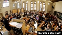 In this Oct. 21, 2019, photo, conductor David Shipps, front left, directs the orchestra during the recording of a video game soundtrack in Nashville, Tenn.
