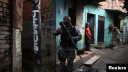 A military police officer patrols the Kelson's slum during an operation against crime in Rio de Janeiro, Brazil, Feb. 20, 2018. 