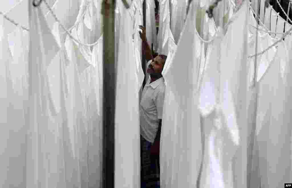 A laundry worker hangs freshly washed sheets at one of the city&#39;s oldest laundry facilities, or &#39;dhobi ghats,&#39; in Chennai, India.