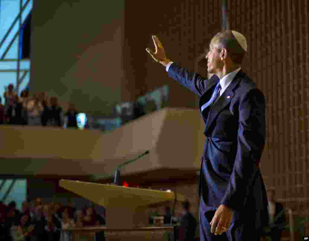 O Presidente Barack Obama, a usar um solidéu judeu tradicional, acena à sua audiência depois do seu discurso na Congregação de Adas Israel como parte do &quot;Mês da Herança Judaica Americana,&quot; em Washington, 22 de Maio, 2015.