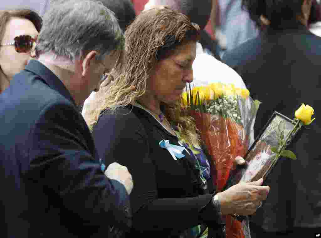 A mourner holds a photo of her loved one during the 15th anniversary of the attacks of the World Trade Center at the National September 11 Memorial in New York, Sept. 11, 2016.