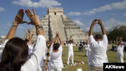 People raise their arms towards the sun while standing in front of the Kukulcan pyramid in Chichen Itza March 20, 2011.