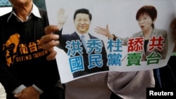 A pro-independence protester holds a sign with images of Nationalist Party, or Kuomintang (KMT), chairwoman Hung Hsiu-chu and China's President Xi Jinping during a protest against their meeting, at the airport in Taoyuan, Taiwan October 30, 2016. 