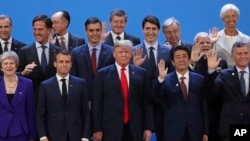 President Donald Trump, front center, stands with other world leaders as they pose for a group picture at the start of the G-20 Leader's Summit inside the Costa Salguero Center in Buenos Aires, Argentina, Nov. 30, 2018. From left, front, are Britain's Pri