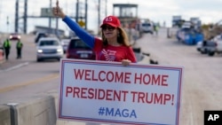 Seorang pendukung mantan presiden AS Donald Trump menunggu iring-iringan kendaraan yang membawa Trump ke resornya Mar-a-Lago, di Palm Beach, Florida, Rabu, 20 Januari 2021. 