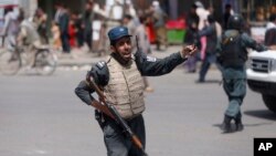 Un policier afghan s'active après un attentat à la voiture piégée près du siège de la police à Kaboul, en Afghanistan, le mercredi 7 août 2019.