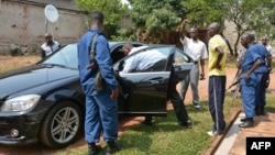 Police officers inspect the vehicle of minister Hafsa Mossi, a close ally of President Pierre Nkurunziza, after she was killed on July 13, 2016 in Burundian capital, Bujumbura. 