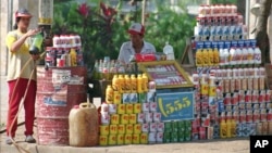 A vendor's wife fills up a two-littre bottle with gasoline for sale at a roadside stall in Phnom Penh, file photo. 