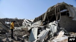 FILE - A Yemeni man inspects destruction at a charity's destroyed food aid storage facility, following a reported Saudi-led coalition airstrike on the Yemeni port city of Hodeidah