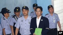 Lee Jae-yong, second from right, vice chairman of Samsung Electronics Co., arrives for his trial at the Seoul Central District Court in Seoul, South Korea, Aug. 7, 2017. 