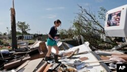 Dillan Taylor salvages items from her storm-ravaged recreational vehicle in Oklahoma City, May 7, 2015.