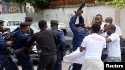 FILE - Congolese police officers attempt to disperse members of the Civil Society Action Collective (CASC) chanting slogans as they protest to demand free fair elections in Kinshasa, Democratic Republic of Congo, Sept. 19, 2018.