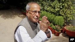 Indian Finance Minister Pranab Mukherjee gestures as he arrives for the Congress Working Committee (CWC) meeting in New Delhi, India, Monday, June 25, 2012. 