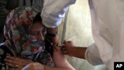FILE - A woman receives a COVID-19 vaccine on July 11, 2021, in Kabul, Afghanistan. The dose was donated by the United States and delivered through the COVAX program.