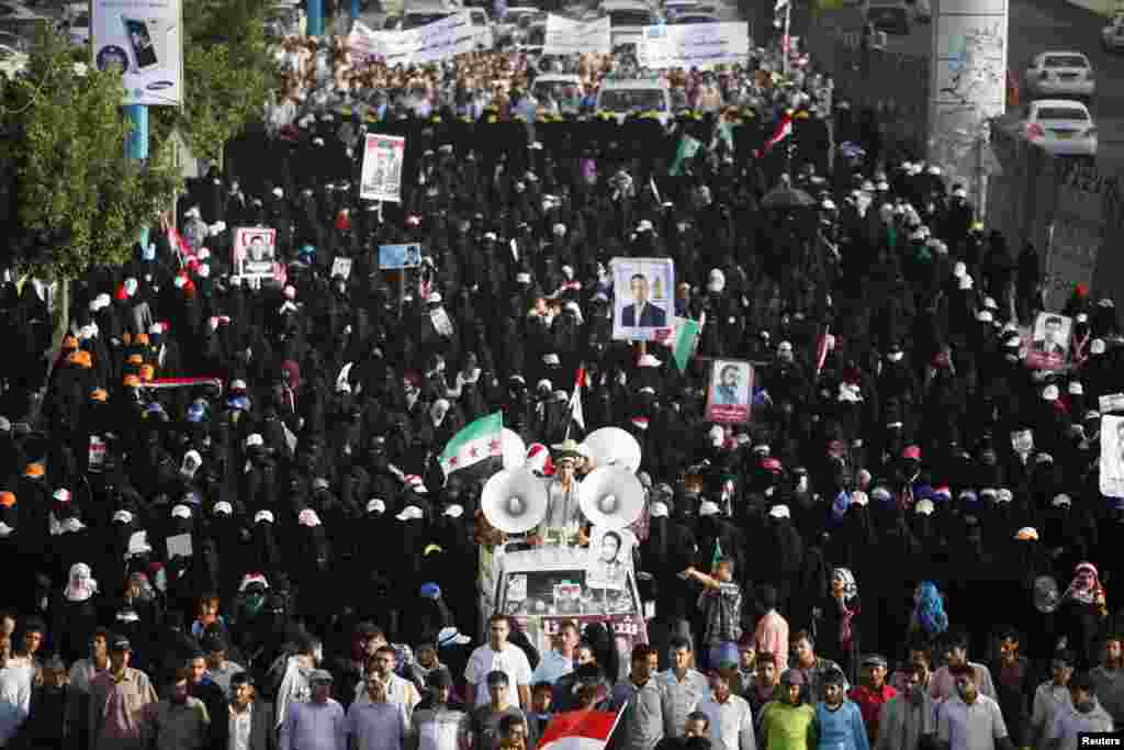 Women pro-democracy protesters march on a road past the house of Yemen&#39;s President Abd-Rabbu Mansour Hadi, during a demonstration to hail a military shake-up he carried out, in Sana&#39;a. Hadi removed the commander of the elite Republican Guard, a powerful political foe, from the military, state television reported, in an apparent move to unify the divided armed forces under his own control.