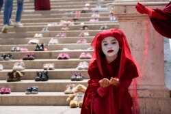 Aktivis gerakan perlindungan lingkungan Extinction Rebellion, melakukan protes selama pertemuan para menteri Ekonomi dan Keuangan G20 dan Gubernur Bank Sentral di Venesia, Italia, Minggu, 11 Juli 2021. (AP Photo/Luca Bruno)