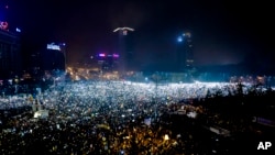 Tens of thousands of people shine lights from mobile phones and torches during a protest in front of the government building in Bucharest, Romania, Sunday, Feb. 5, 2017. 