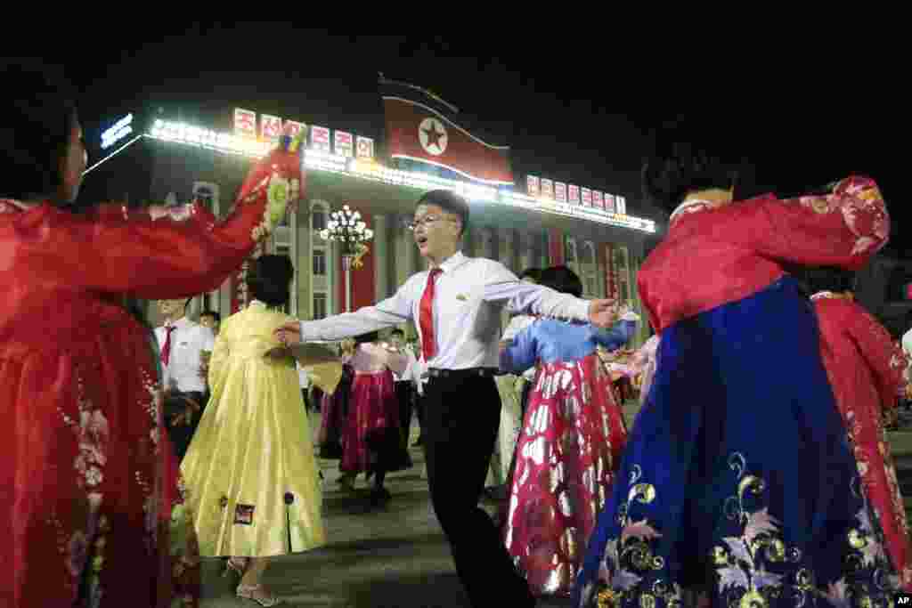 북한의 &#39;화성-14&#39; 시험발사 성공을 자축하는 청년들이 평양 김일성광장에서 열린 무도회에서 춤을 추고 있다. 여학생들은 한복을 입고 남학생들은 빨간 넥타이를 메고 있다.