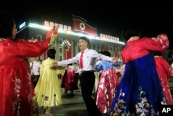 People dance in Kim Il Sung Square in Pyongyang, North Korea, Thursday, July 6, 2017, to celebrate the test launch of North Korea's first intercontinental ballistic missile two days earlier