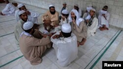FILE - Pakistani religious students and teachers attend a discussion session at the Ganj Madrassa in Peshawar, Aug. 21, 2013.