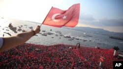 Seorang pria melambaikan bendera Turki saat ribuan orang pendukung Muharrem Ince, kandidat presiden Turki yang mewakili Partai Rakyat Republik, hadir dalam rapat akbar di Izmir, 21 Juni 2018 (foto: AP Photo/Emre Tazegul)