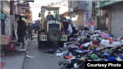 北京當局驅趕走外來務工者後清理他們遺落的衣物和物品。（網絡視頻截圖）