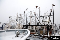 Snow-covered fishing boats are seen in New Bedford, Massachusetts, Dec. 14, 2017.