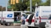 Petugas Kantor Pos As (USPS) tampak tengah memasukan paket ke dalam truk pengiriman di luar sebuah kantor pos di Royal Oak, Michigan, pada 22 Agustus 2020. (Foto: Reuters/Rebecca Cook)