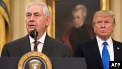 Rex Tillerson habla después de haber asumido el cargo de Secretario de Estado de EE.UU., mientras es escuchado por el presidente Donald Trump.