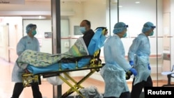 ဟောင်ကောင်တွင် Corona ဗိုင်းရပ်စ် ကူးစက်မှု သံသယရှိ လူနာအား ဆေးရုံသို့ ခေါ်ဆောင်လာသည့် ကျန်းမာရေးဝန်ထမ်းများ။ (ဇန်နဝါရီ ၂၂၊ ၂၀၂၀)