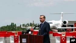 Turkish Prime Minister Recep Tayyip Erdogan delivers a speech near soldiers 'coffins at Van airport, eastern Turkey, 19 Jun 2010