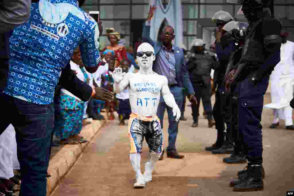 Un homme couvert de peinture blanche saluant l&#39;arrivée de l&#39;ancien président du Mali Amadou Toumani Touré à Bamako, le 24 décembre 2017.