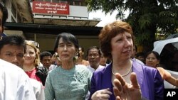 Burma's pro-democracy leader Aung San Suu Kyi (C) walks next to European Union Foreign Policy chief Catherine Ashton after their meeting and news conference in front of the National League for Democracy head office in Rangoon, April 28, 2012. 