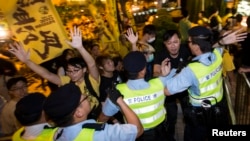 民主派活动人士在前来宣布北京特首产生方案的中国人大官员李飞下榻的酒店外与香港警察发生推搡。（2014年9月1日）